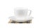 White coffee cup and saucer on a wooden napkin