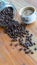 White coffee cups and coffee beans that spill around with wooden table backgrounds