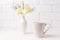 White coffee latte mug mockup with soft yellow orchid in vase