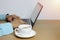 white coffee mug on brown wooden floor and computer laptop of Ha