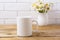 White coffee mug mockup with chamomile bouquet in rustic vase