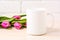 White coffee mug mockup with magenta pink tulips bouquet