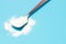 White collagen powder in teaspoon on a blue background, a copy of the space