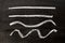 White color chalk hand drawing as line shape on black board