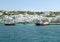 White colored Greek islands architecture on the hillside with vivid color boats at the Mykonos Old Port, Greece