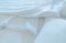 White comfort bed and soft pillow in modern bedroom. White linen blanket in hotel bedroom. Closeup detail of messy white blanket