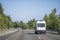 White compact mini van for commercial transportation freights driving on the divided highway road