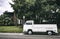 White compact van parked on the road near the trees