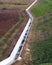 white concrete ditch on the field to transport water for irrigation