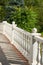 White concrete railing with columns close-up on a sunny day, decorative hedge