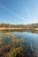 White contrails reflected in the mirror smooth water surface