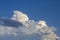 White contrasting clouds backlit by the sun on a blue summer sky. Background.