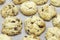 White cookies with pieces of chocolate on white backing paper