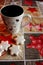 White cookies stars and cup decorated with elks on festive tablecloth with stars and wooden pattern.