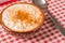 White corn cooked with milk known as canjica, canjicÃ£o or mungunza, in a rustic bowl on wooden table. Typical dish of Brazilian