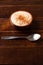 White corn cooked with milk known as canjica, canjicÃ£o or mungunza, in a rustic bowl on wooden table. Typical dish of Brazilian