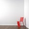 White corner room with red chair