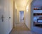 White corridor with built-in closets and open doors