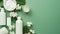 white cosmetic bottle eucalyptus flower towels soap on a green background