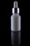 White cosmetic bottle with an eyedropper is isolated on a black background