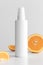 White cosmetic lotion bottle mockup with oranges  on a white table