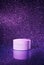 White cosmetic mockup package design with moisturizer cream on sparkling purple background starry sky imitation.