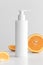 White cosmetic shampoo dispenser bottle mockup with oranges  on a white table