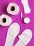 White cosmetic slippers, hygiene items, gasket, tampon, cotton pads, toilet paper on pink background top view flat lay. Cosmetics