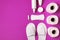 White cosmetic slippers, hygiene items, gasket, tampon, cotton pads, toilet paper on pink background top view flat lay. Cosmetics