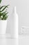 White cosmetic spray bottle mockup with a aloe vera and towels on a white table