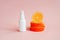 White cosmetic spray bottle and orange slices on pink background. Hair natural oil, body mist, sanitizer, perfume, sunscreen oil