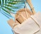 White cotton bag, wooden forks, plates and cups on a blue background. Waste recycling concept, zero waste