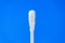 White cotton swab or or cotton bud against blue background.