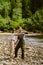 White couple pointing fingers aside while hiking by river in nature