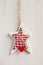 White craft star Christmas decoration hanging on white background vertical