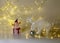 White crocheted deer Rudolph, Santa Claus and various Christmas decorations, illuminated white light chain background, Christmas