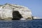 White cruise ship in front of a rock formation with a cave near Bonifacio port