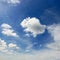 White cumulus clouds against the background of an epic blue sky.