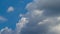 White cumulus clouds on a blue sky. Time Lapse.