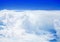 White cumulus clouds on clear blue sky background, aerial cloudscape panoramic view from airplane, high azure skies panorama