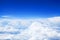 White cumulus clouds clear blue sky background, scenic aerial cloudscape view from airplane, high azure skies backdrop
