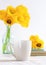 White cup on a background of yellow tulips