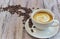 White cup with black coffee with milk. Handful of coffee beans on a wooden table. horizontal view of a cup with a coffee drink.