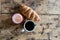 white cup of black coffee with teaspoon on a rough wooden table