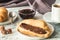 White cup of black tea with croissant or toasts with peanut butter, chokolate paste , jelly or jam on white wooden table, Breakfas