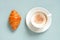 White cup of cappuccino with fresh croissant on the light blue table