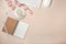 White cup with cappuccino, sakura flowers, keyboard, alarm clock, notebook on a pastel pink background