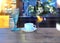 White  cup of coffee and blue glass of wine on wooden table at street cafe sunlight reflection on windows city urban life stile