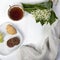 White cup of coffee, a bouquet of lilies of the valley, a notepad for notes and a saucer with two brownie cookies. Breakfast. Copy