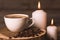 White cup of coffee, candles, and coffee beans